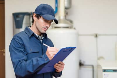 A man in blue shirt writing on paper.