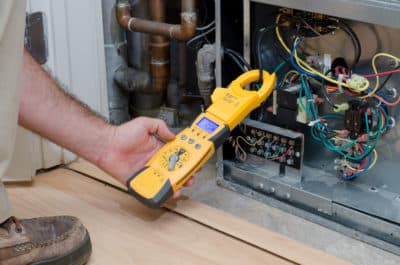 A person holding an electrical tool in their hand.